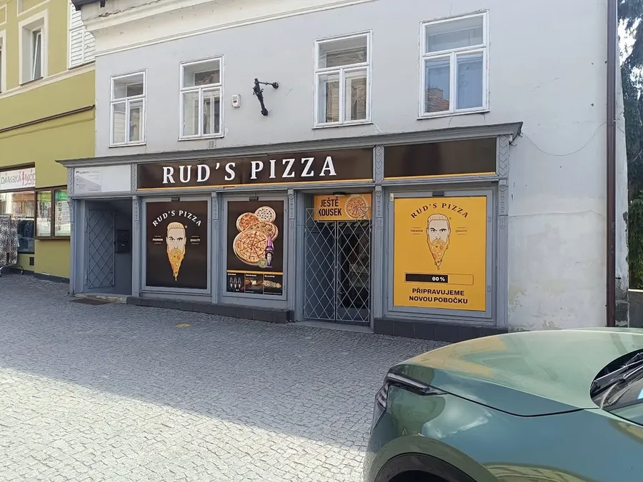 Výloha pizzerie Rud's Pizza s reklamními potisky na oknech